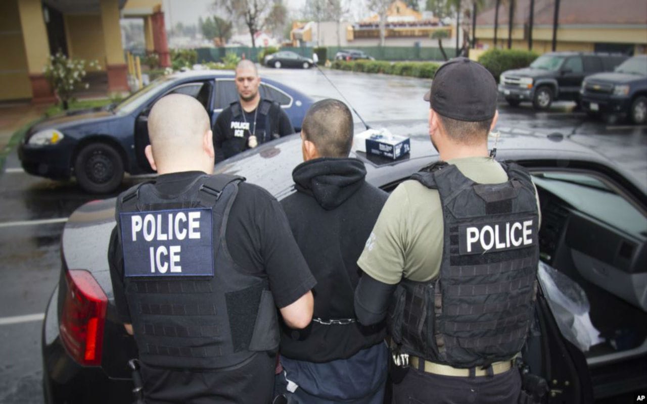 Agentes de ICE arrsteando a un migrante